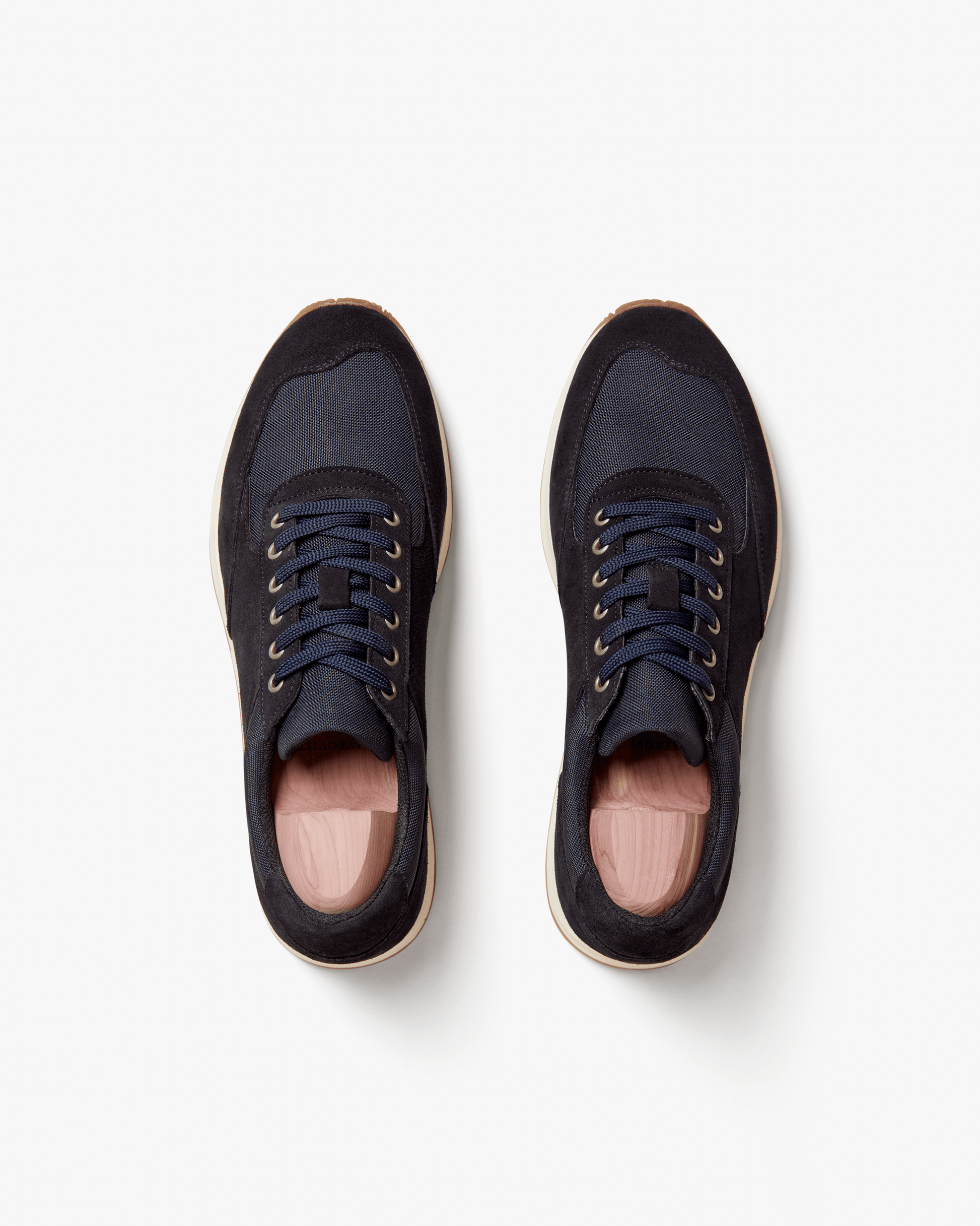 Stensund in navy suede shown from above, highlighting the deep navy suede and tonal mesh panels, lace-up closure, and natural-toned rubber sole with gum detailing. The clean, athletic silhouette and subtle color palette emphasize its versatility for both tailored trousers and denim.