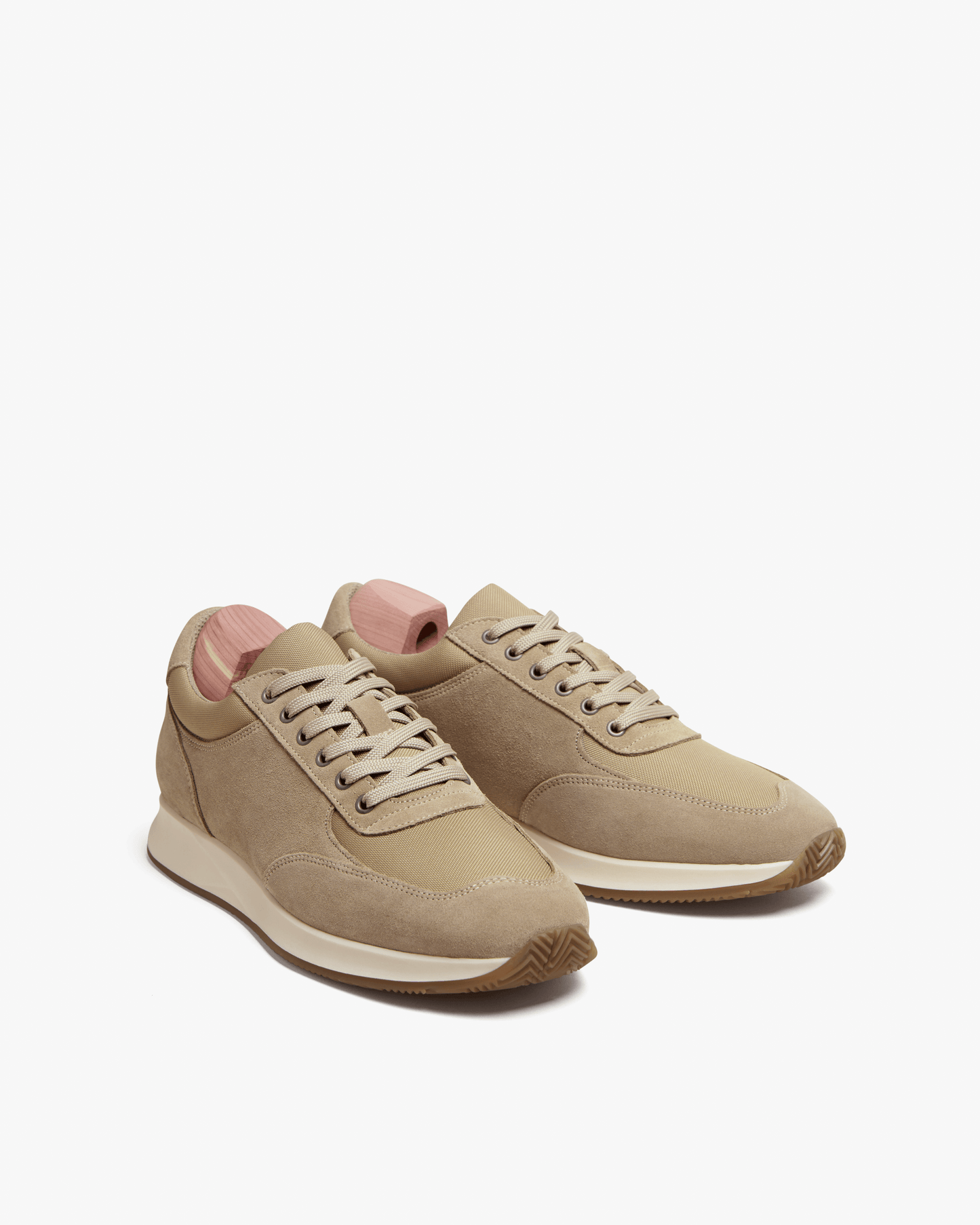 Stensund in sand suede displayed at an angle, featuring soft beige suede, tonal mesh panels, and a sculpted rubber sole for a contemporary, versatile look.