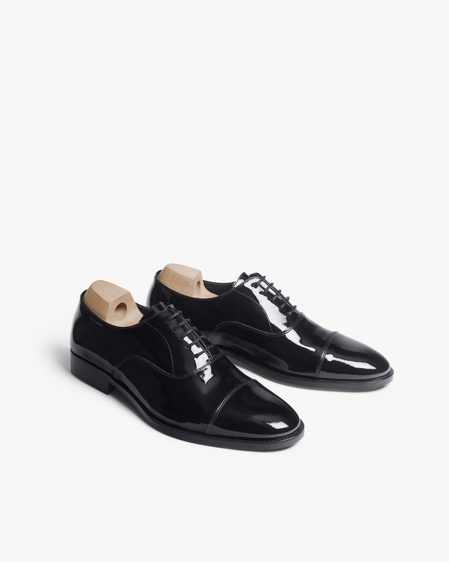 Vinterviken II oxford shoes in black patent leather with a high-gloss finish, softly rounded cap toes, and wooden shoe trees, ideal for pairing with tuxedos or formal suits.
