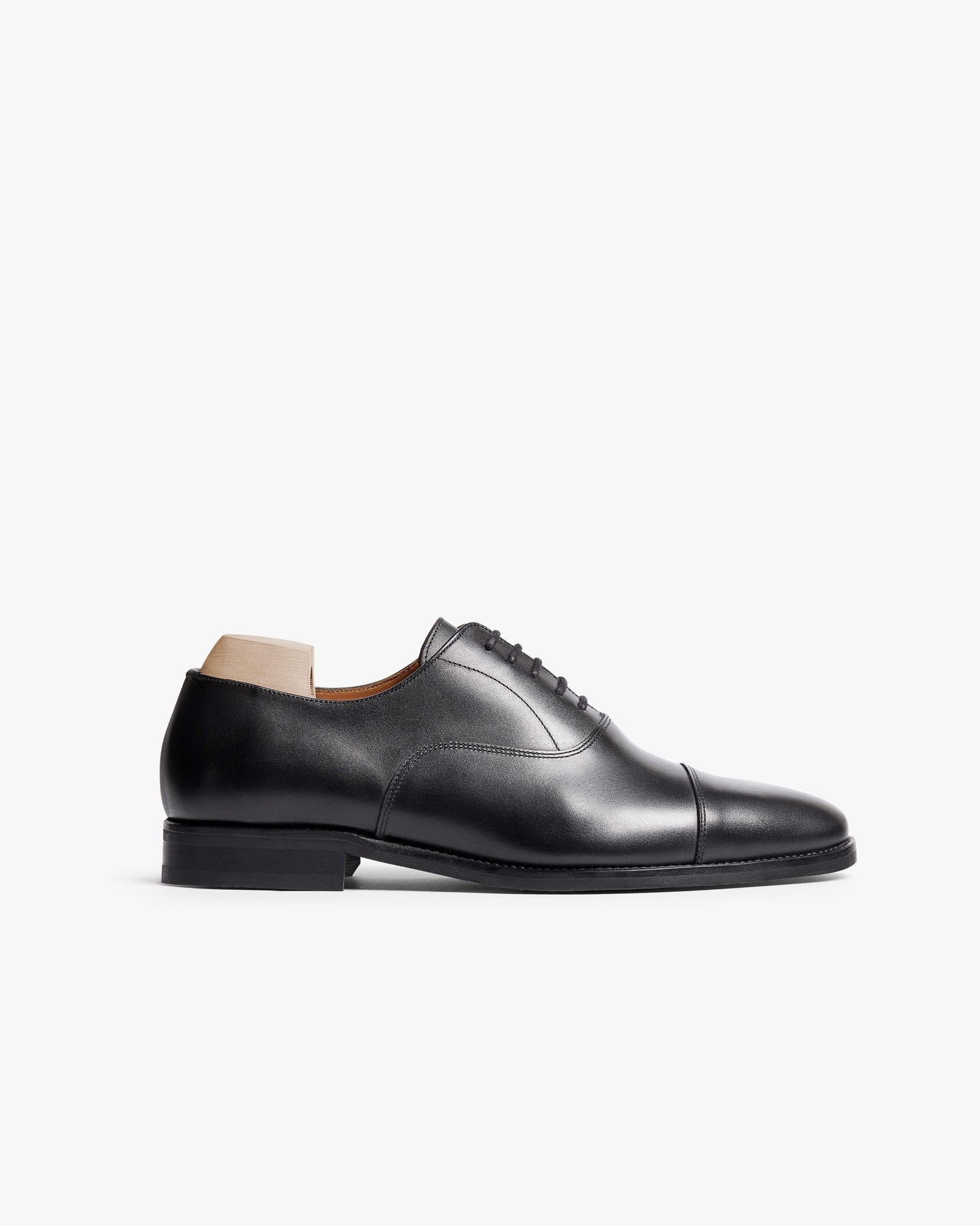 Vinterviken II in black calf features a classic oxford silhouette with a gently rounded cap toe, polished full-grain leather upper, and sleek black sole, shown in a side profile against a white background.