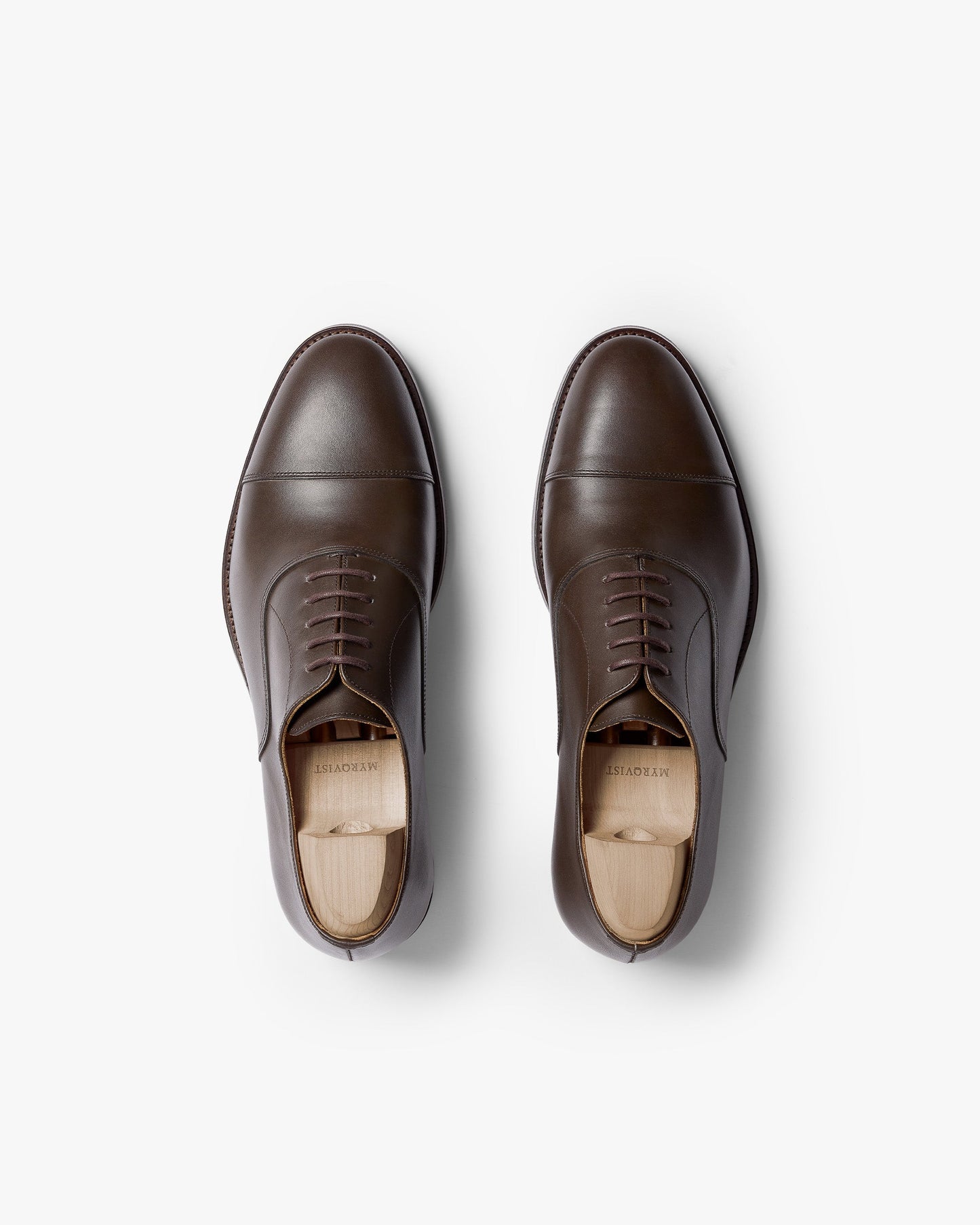 Vinterviken II in dark brown calf, a pair of classic oxford shoes with chiseled cap toes and clean stitching, shown from above with wooden shoe trees inserted.