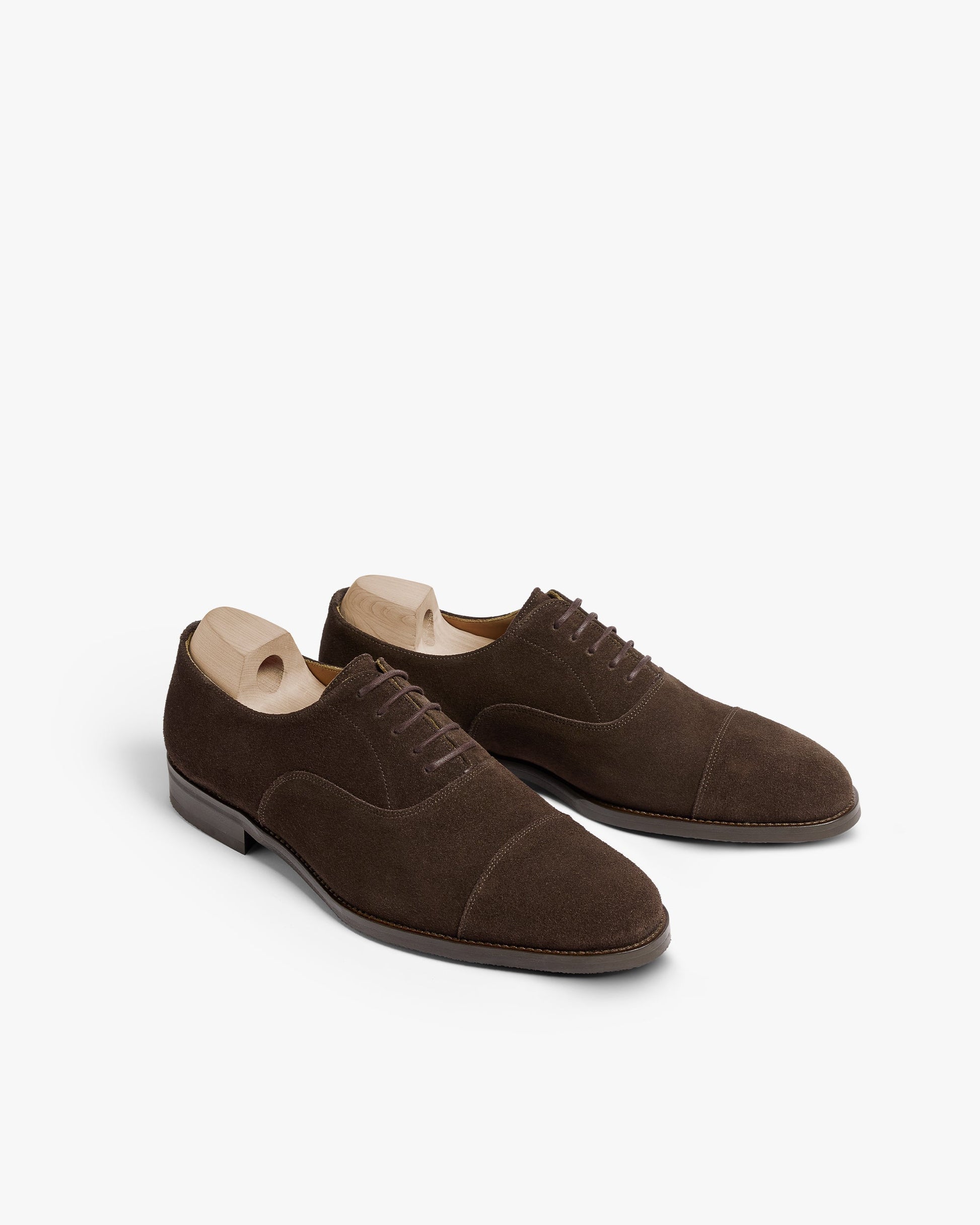Vinterviken II oxford shoes in dark brown suede displayed at an angle, featuring a softly chiseled cap toe, smooth suede texture, and wooden shoe trees inside for shape retention.