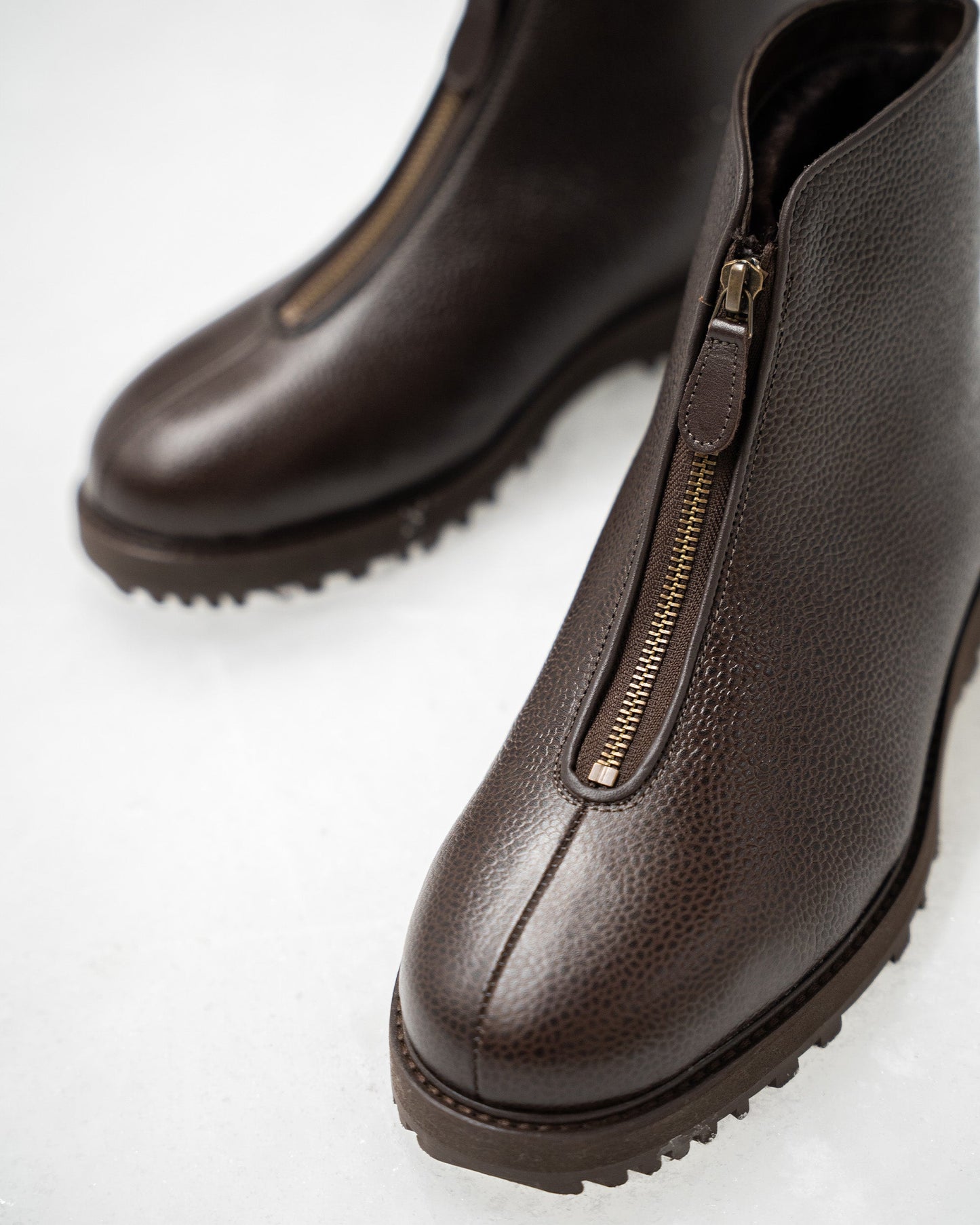 Close-up of Funäs in dark brown country calf, featuring textured leather, a central zipper with a leather pull, and a durable Explorer sole ideal for winter wear.