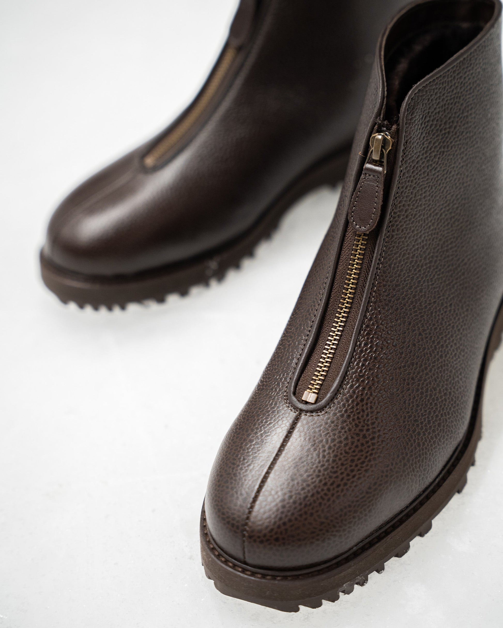 Close-up of Funäs in dark brown country calf, featuring textured leather, a central zipper with a leather pull, and a durable Explorer sole ideal for winter wear.