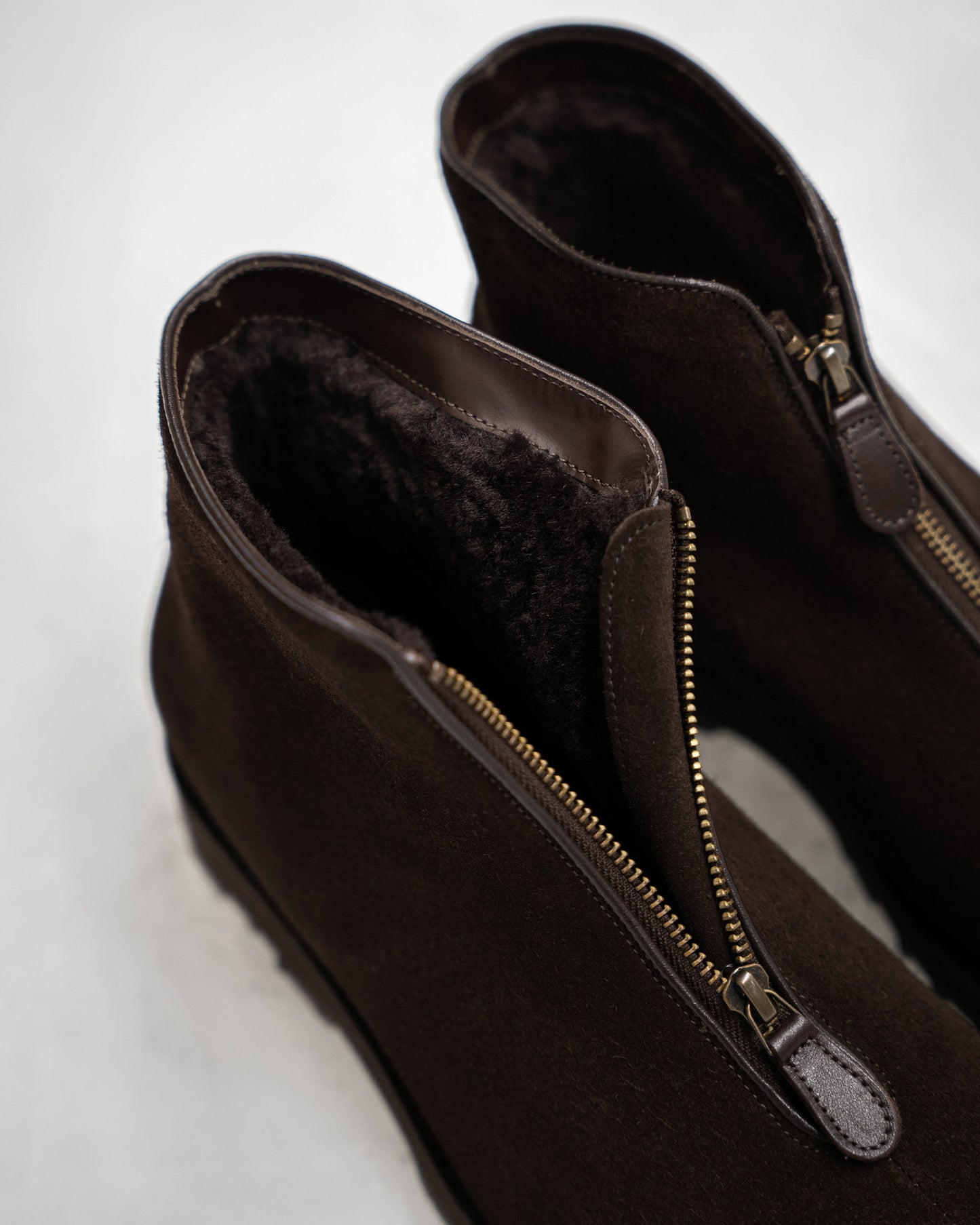 Close-up of Funäs in dark brown suede, highlighting the plush shearling lining and central zipper closure for easy wear and warmth. The soft suede texture and detailed stitching emphasize the boot’s refined winter style.